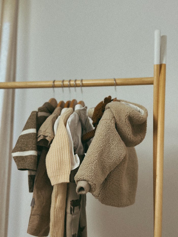 The Art of Drawing Readers In: Your attractive post title goes here A selection of brown and beige childrens clothing hanging on a wooden rack indoors.